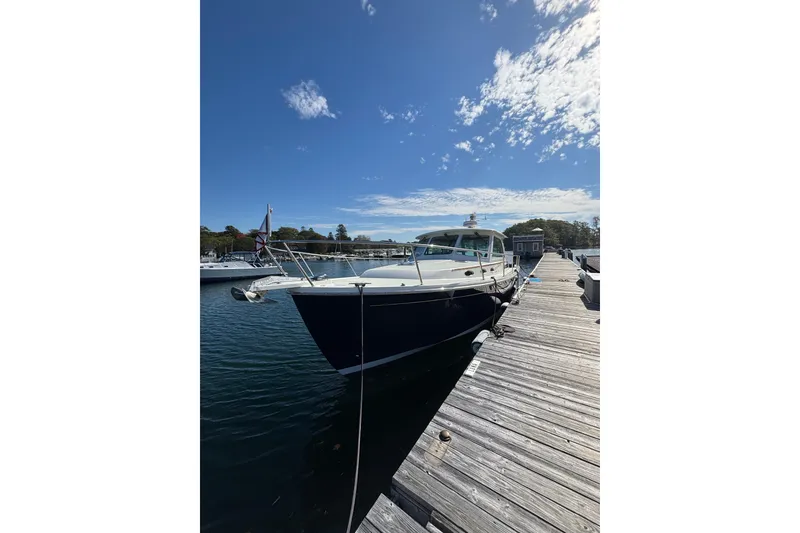 Slide: The Image of 2020 Back Cove 37 yacht docked at a marina under a clear blue sky. - 5