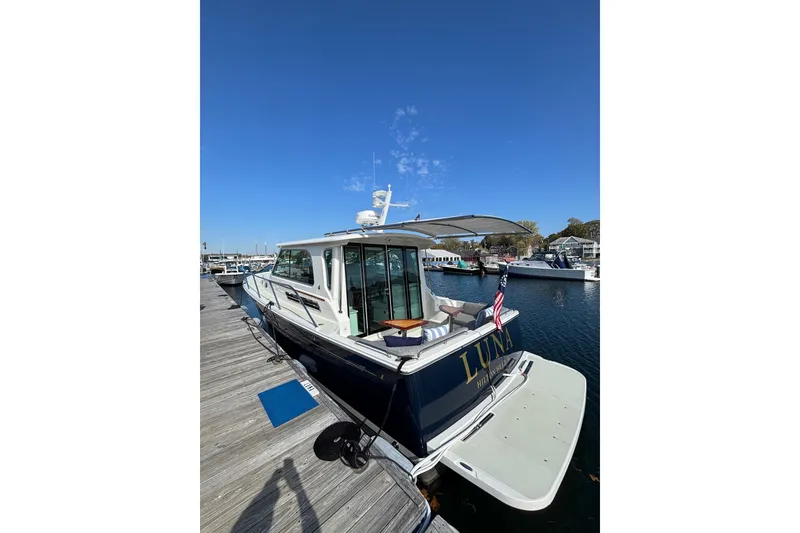 Slide: The Image of 2020 Back Cove 37 yacht docked, featuring sleek design and spacious deck. - 6