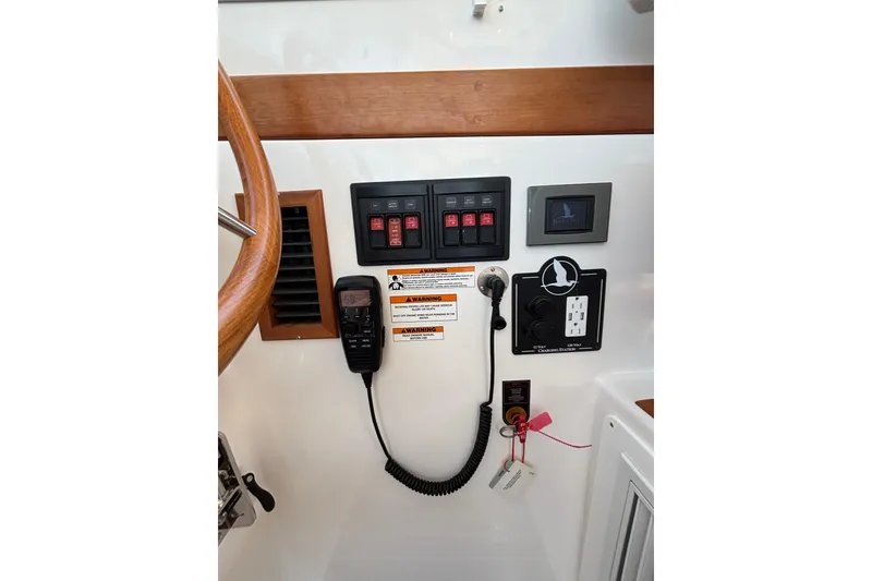 Slide: The Image of Control panel of 2020 Back Cove 37 boat with switches and communication equipment. - 62