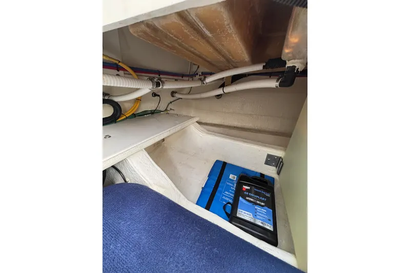 Slide: The Image of 2020 Back Cove 37 boat interior showing storage compartment with cables and antifreeze container. - 75