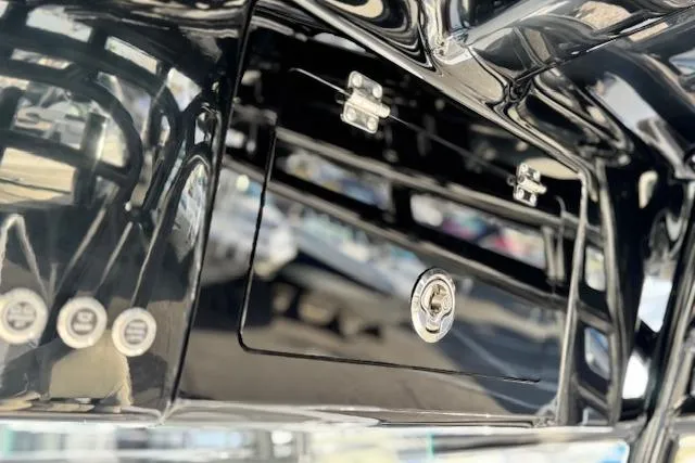 Slide: The Image of 2026 Cape Horn 34 XS boat dashboard with sleek black finish and secure storage compartment. - 22