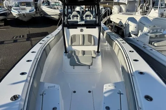 Slide: The Image of 2026 Cape Horn 34 XS boat interior with seating and console, docked among other boats. - 14