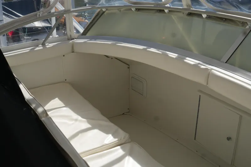 Slide: The Image of 1977 Bertram 46.6 boat interior with white seating and window view. - 14