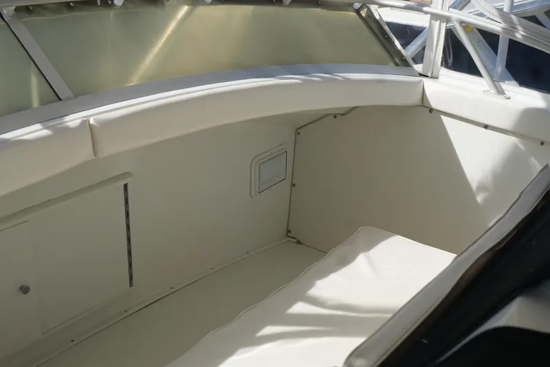 Slide: The Image of 1977 Bertram 46.6 boat interior with white seating and storage compartments. - 15