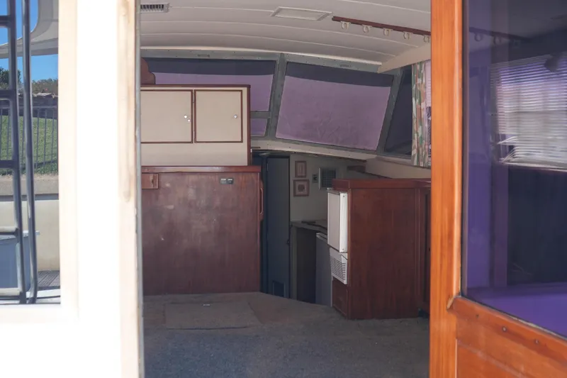 Slide: The Image of Interior of a 1977 Bertram 46.6 yacht, featuring wooden cabinetry and carpeted flooring. - 18