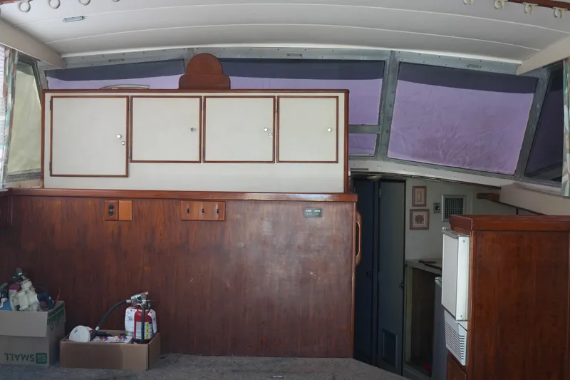 Slide: The Image of Interior of a 1977 Bertram 46.6 yacht with wooden cabinetry and large windows. - 19