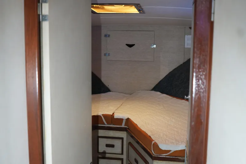 Slide: The Image of 1977 Bertram 46.6 yacht cabin interior with bed and storage compartments. - 20