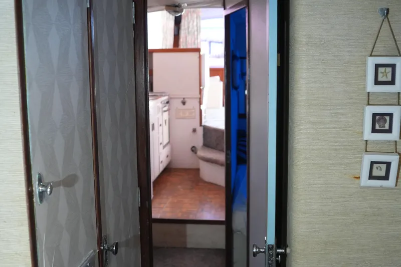 Slide: The Image of Interior view of a 1977 Bertram 46.6 yacht, featuring a cozy cabin and hallway. - 21
