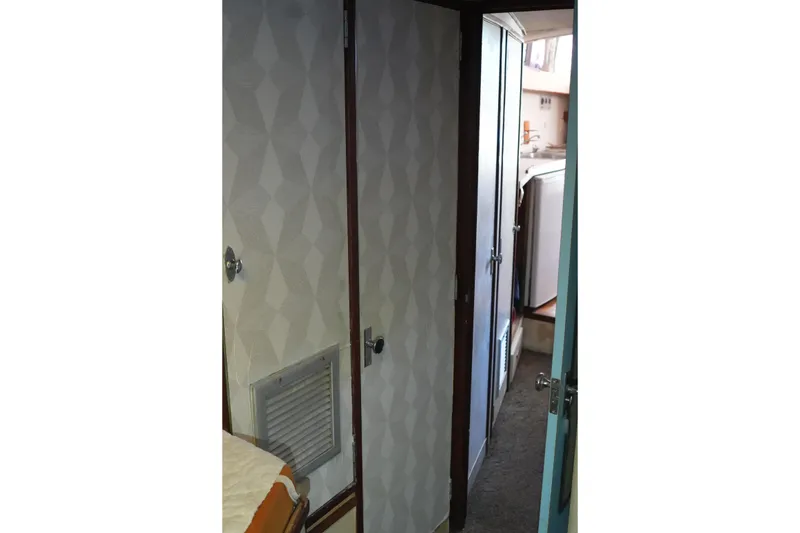 Slide: The Image of Interior hallway of a 1977 Bertram 46.6 yacht, featuring patterned walls and visible cabin doors. - 22