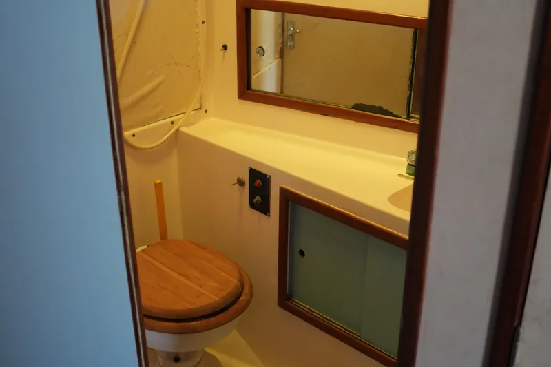 Slide: The Image of 1977 Bertram 46.6 yacht bathroom with wooden toilet seat and mirror. - 23