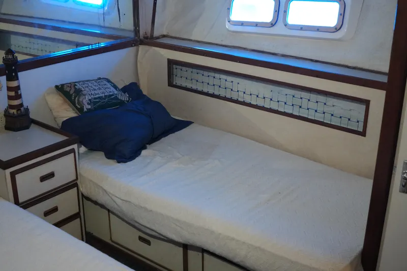 Slide: The Image of Cozy cabin interior of 1977 Bertram 46.6 yacht with single bed and nautical decor. - 26
