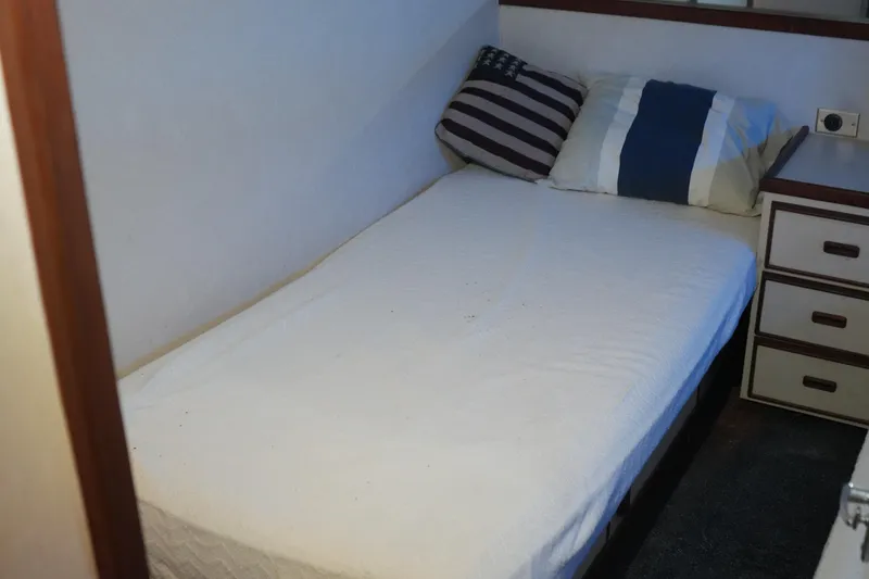 Slide: The Image of Cozy cabin bed with striped pillows in a 1977 Bertram 46.6 yacht interior. - 27