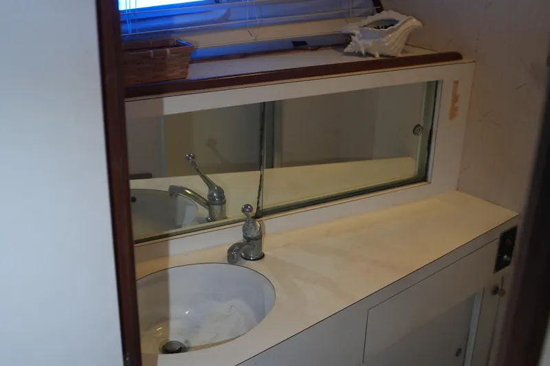 Slide: The Image of 1977 Bertram 46.6 yacht bathroom with sink, mirror, and decorative shell. - 29