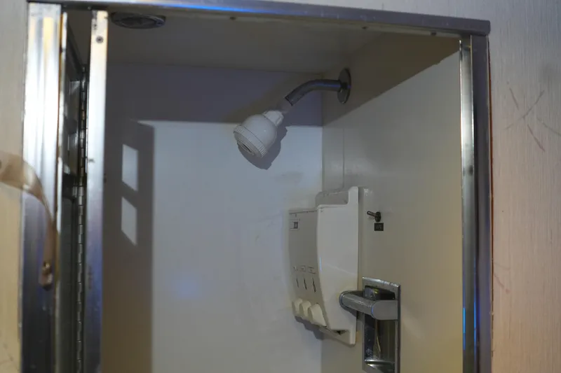 Slide: The Image of Shower area inside a 1977 Bertram 46.6 yacht, featuring a showerhead and control panel. - 30