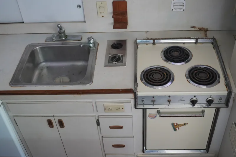 Slide: The Image of 1977 Bertram 46.6 yacht kitchen with sink and vintage stove. - 34