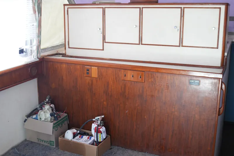 Slide: The Image of 1977 Bertram 46.6 interior with wooden cabinetry and storage boxes. - 36