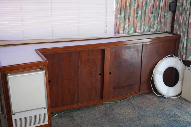 Slide: The Image of Interior of a 1977 Bertram 46.6 yacht with wooden cabinets and a life preserver. - 37