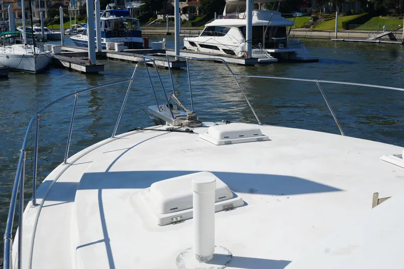 Slide: The Image of 1977 Bertram 46.6 yacht docked at marina with other boats in background. - 7