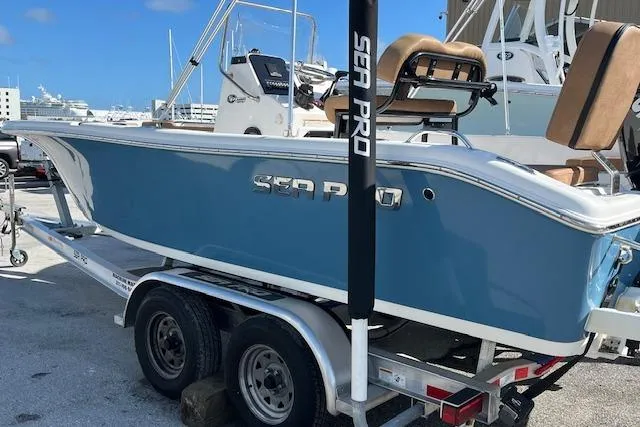 Slide: The Image of 2024 Sea Pro 199 Center Console boat on trailer, blue hull, docked at marina. - 10