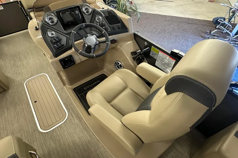 Slide: The Image of 2025 Sylvan L1 DLZ boat interior with steering wheel and beige seating. - 12