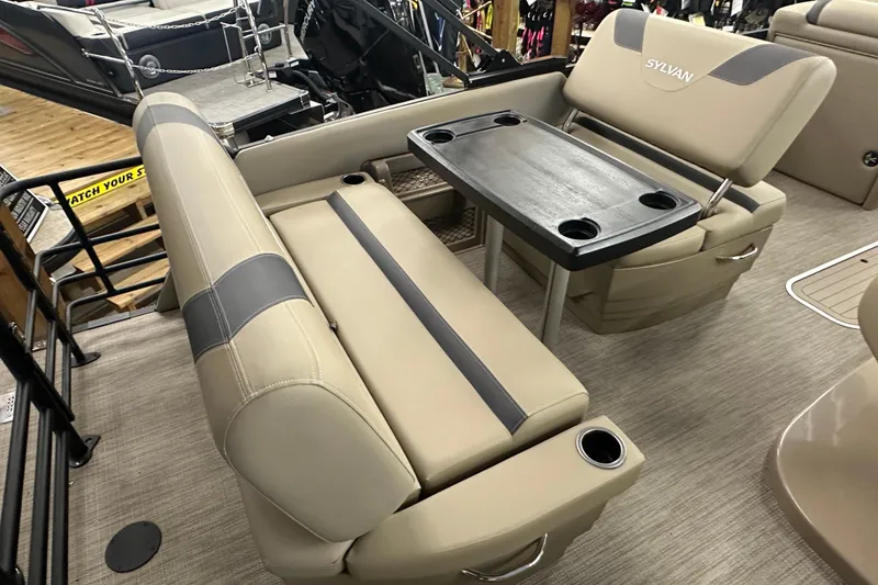 Slide: The Image of 2025 Sylvan L1 DLZ boat interior with beige seating and a central table. - 17