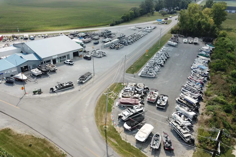 Slide: The Image of Aerial view of Sylvan L1 DLZ 2025 boats at a dealership with surrounding landscape. - 26