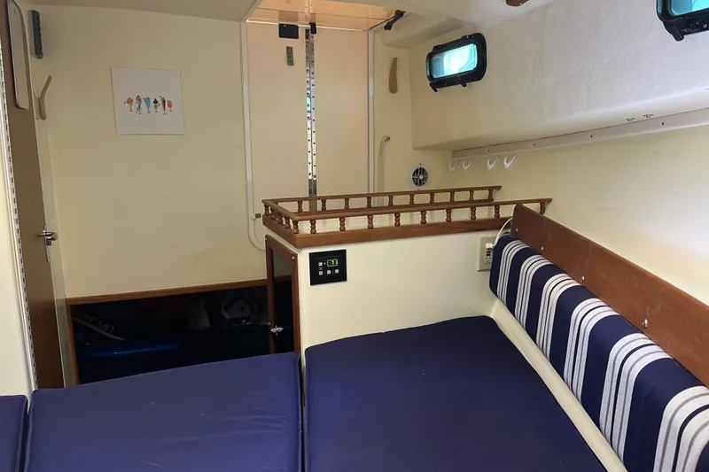 Slide: The Image of 2020 Eastern 27 Islander boat interior with blue cushions and striped seating. - 12