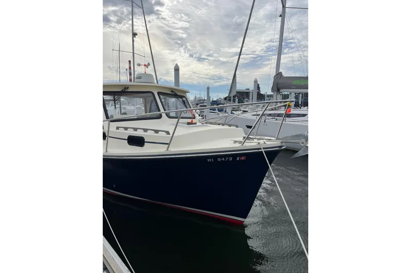 Slide: The Image of 2020 Eastern 27 Islander boat docked at marina under cloudy sky. - 2