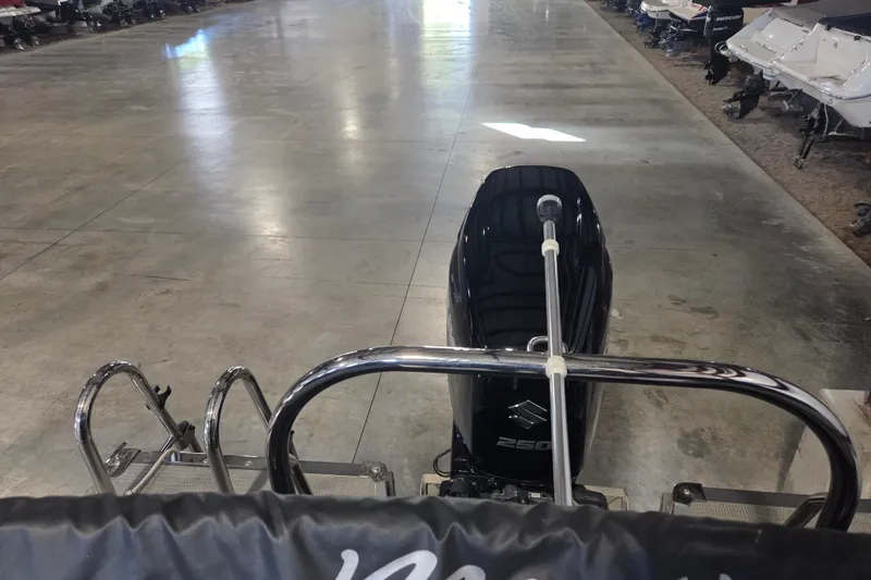 Slide: The Image of 2019 Manitou 23 Encore SHP boat with powerful outboard motor in a showroom. - 10