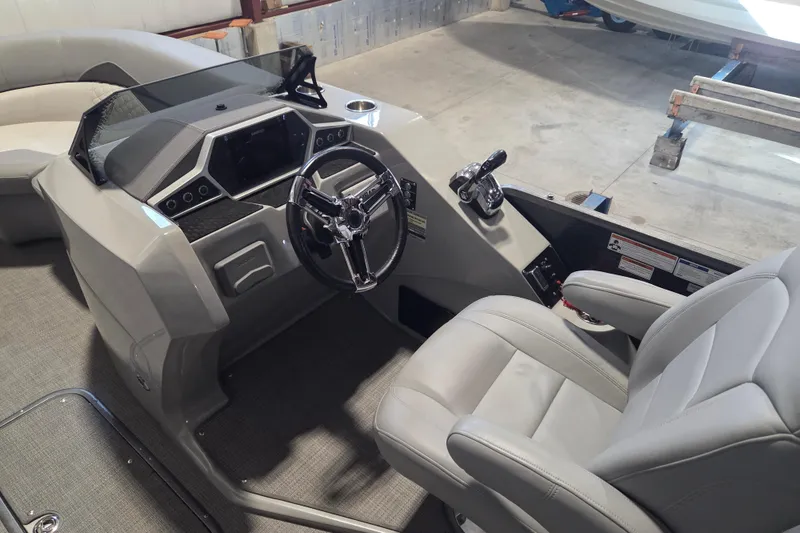 Slide: The Image of 2019 Manitou 23 Encore SHP boat interior with steering wheel and control panel. - 4