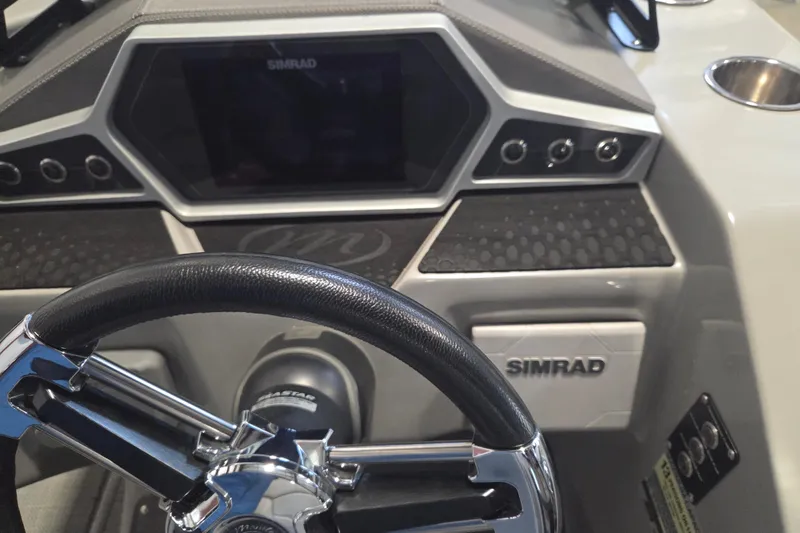 Slide: The Image of 2019 Manitou 23 Encore SHP dashboard with Simrad display and steering wheel. - 8