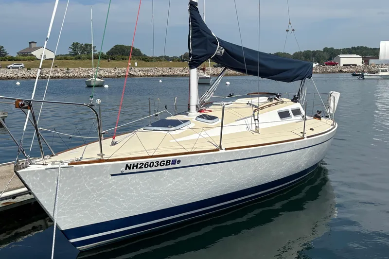 The Image of 1982 J Boats J/30 sailboat docked in a marina, clear sky background. - 1
