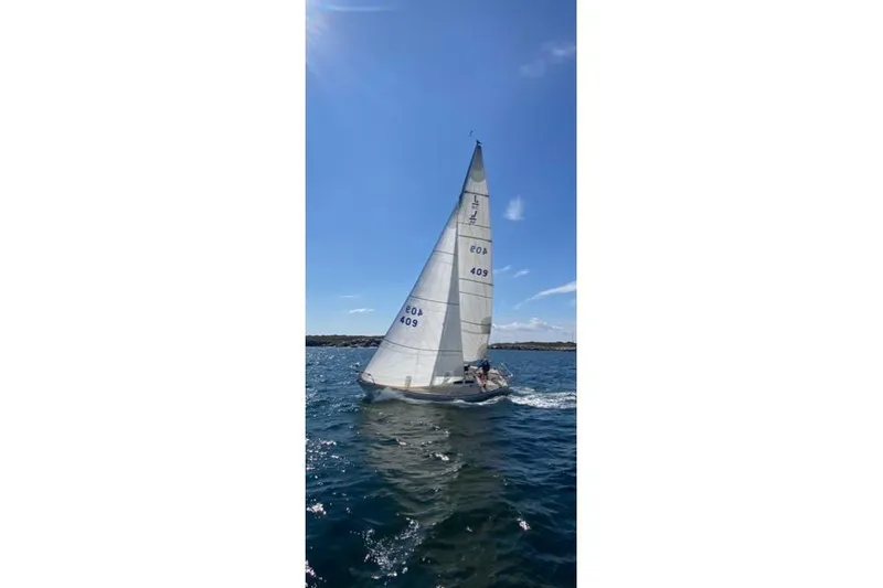 Slide: The Image of 1982 J Boats J/30 sailing on open water under clear blue sky. - 10