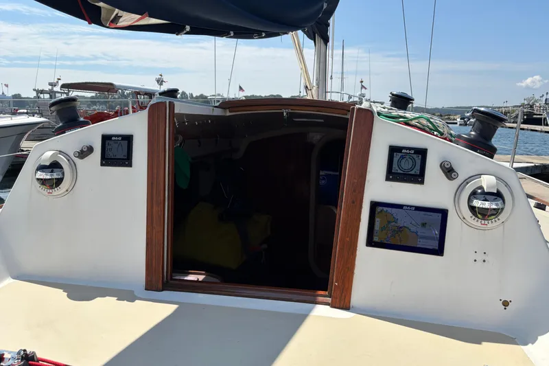 Slide: The Image of 1982 J Boats J/30 sailboat cockpit with navigation instruments and open cabin door. - 6