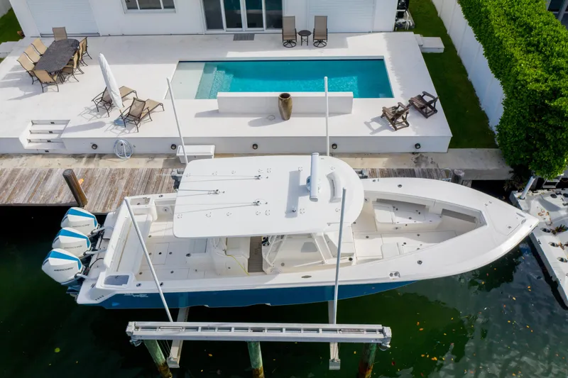 Slide: The Image of 2023 SeaVee 370z boat docked near a modern waterfront home with a pool. - 3