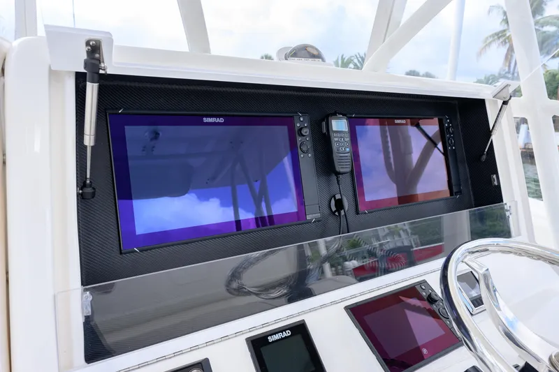 Slide: The Image of 2023 SeaVee 370z boat dashboard with Simrad navigation screens and controls. - 6