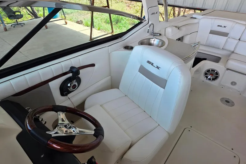 Slide: The Image of 2009 Sea Ray 270 SLX boat interior with white seating and steering wheel. - 14