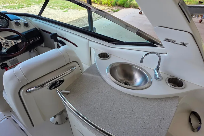 Slide: The Image of 2009 Sea Ray 270 SLX boat interior with steering wheel and sink. - 16