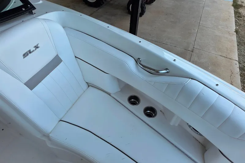 Slide: The Image of White leather seating on 2009 Sea Ray 270 SLX boat, featuring sleek design and cup holders. - 19