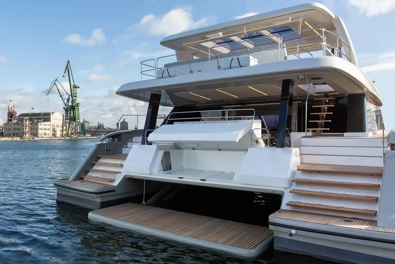 Slide: The Image of 2026 Sunreef 60 Sunreef Power yacht docked, showcasing luxurious multi-level design and spacious deck. - 2