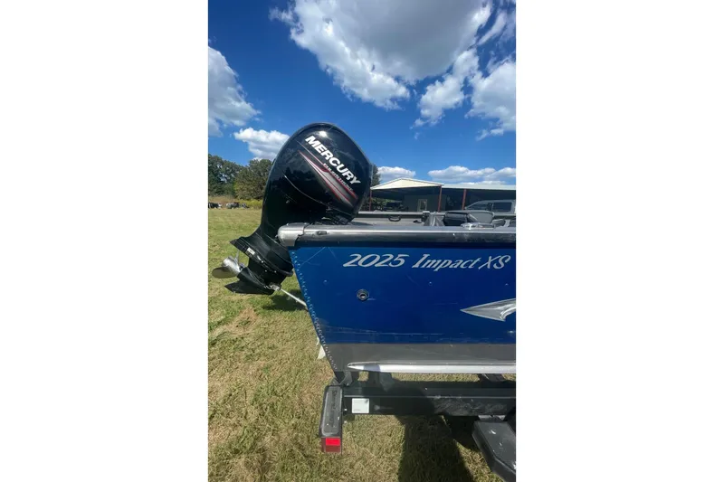 Slide: The Image of 2017 Lund 2025 Impact XS boat with Mercury outboard motor on grassy field. - 5