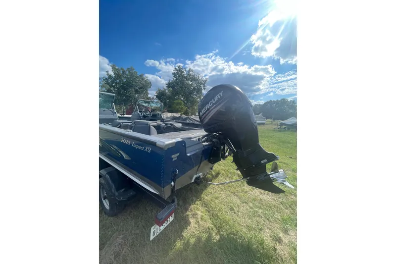 Slide: The Image of 2017 Lund 2025 Impact XS boat with Mercury engine in a grassy field. - 6