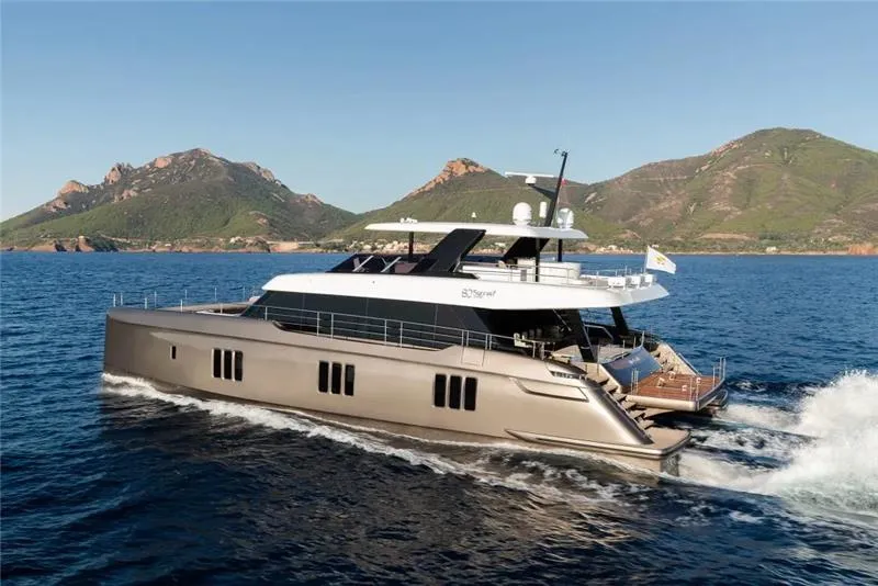 Slide: The Image of 2026 Sunreef 80 Sunreef Power yacht cruising on open water with scenic mountain backdrop. - 9
