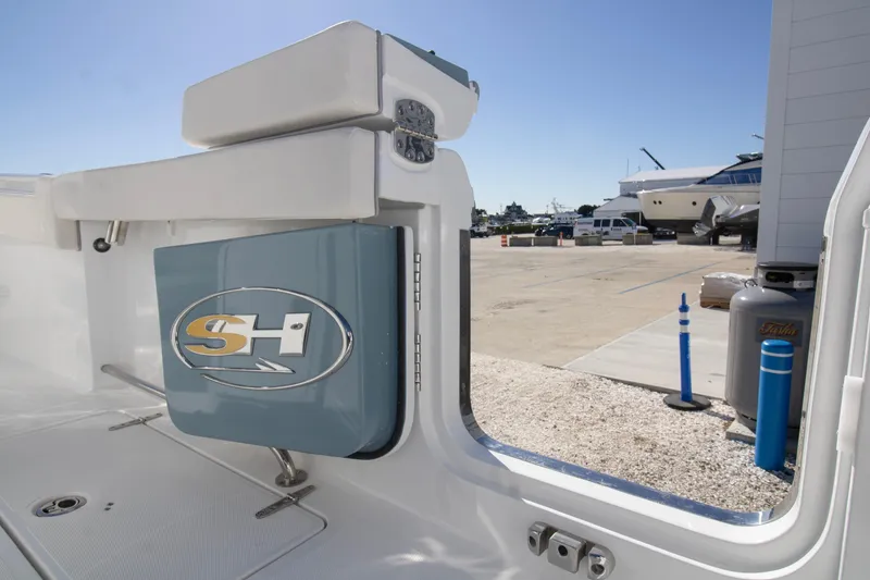 Slide: The Image of 2026 Sea Hunt Gamefish 25 boat interior with logo, dockside view. - 10