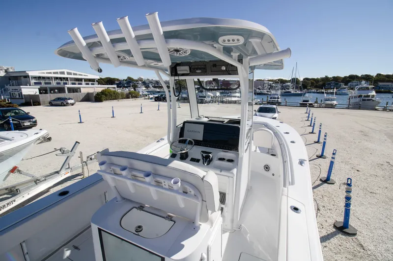 Slide: The Image of 2026 Sea Hunt Gamefish 25 boat with advanced navigation system, docked at a marina. - 11
