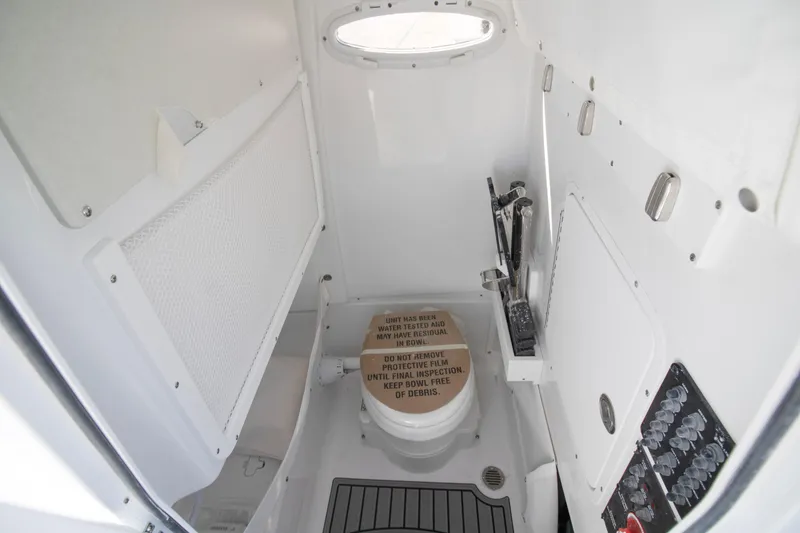 Slide: The Image of 2026 Sea Hunt Gamefish 25 boat interior with compact marine toilet and storage. - 13