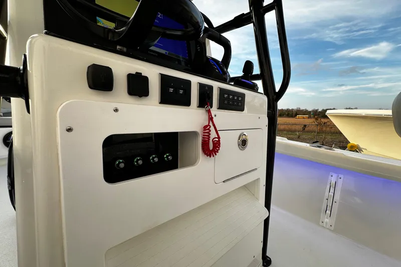 Slide: The Image of 2024 Pair Customs 24DV boat console with controls and scenic background. - 10