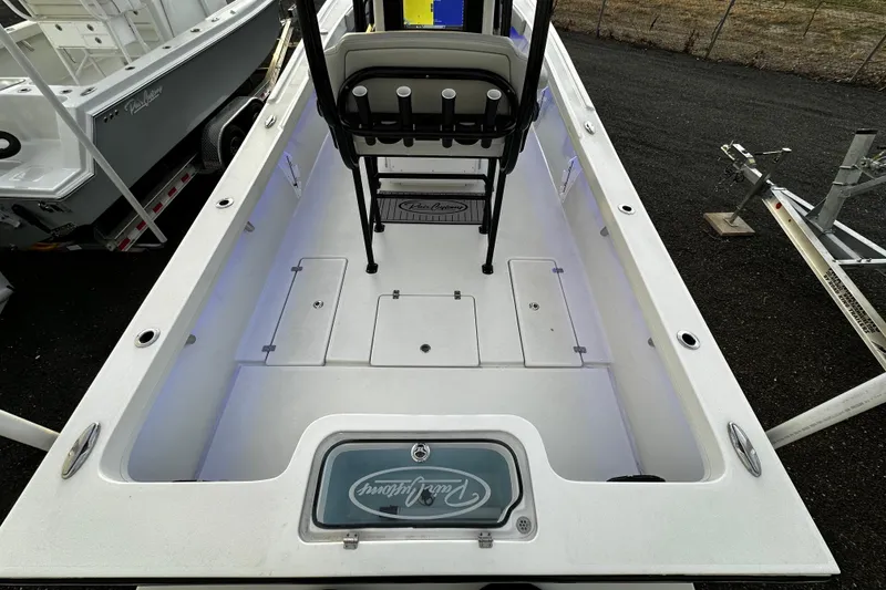 Slide: The Image of 2024 Pair Customs 24DV boat interior with storage compartments and seating. - 12