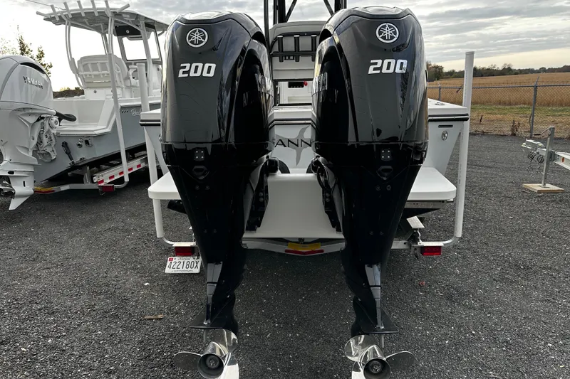 Slide: The Image of 2024 Pair Customs 24DV boat with dual Yamaha 200 outboard engines, parked outdoors. - 6