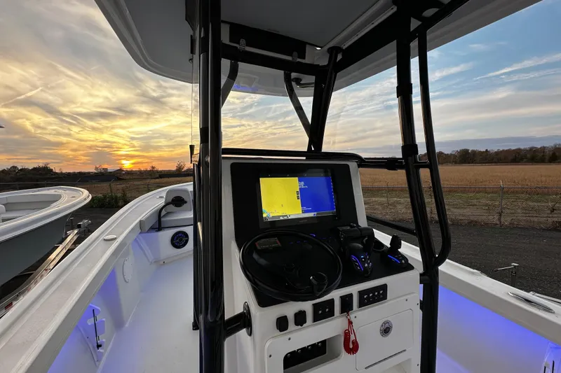 Slide: The Image of 2024 Pair Customs 24DV boat cockpit with sunset view and navigation display. - 8